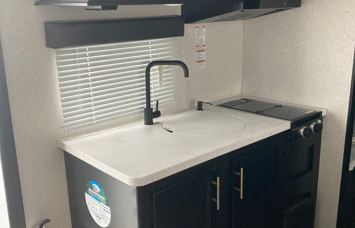 Jake's kitchen comes complete with a large sink, upper and lower cabinet spaces and a two burner stove. Additionally, the the kitchen features a large 11 cubic foot refrigerator & and a microwave.