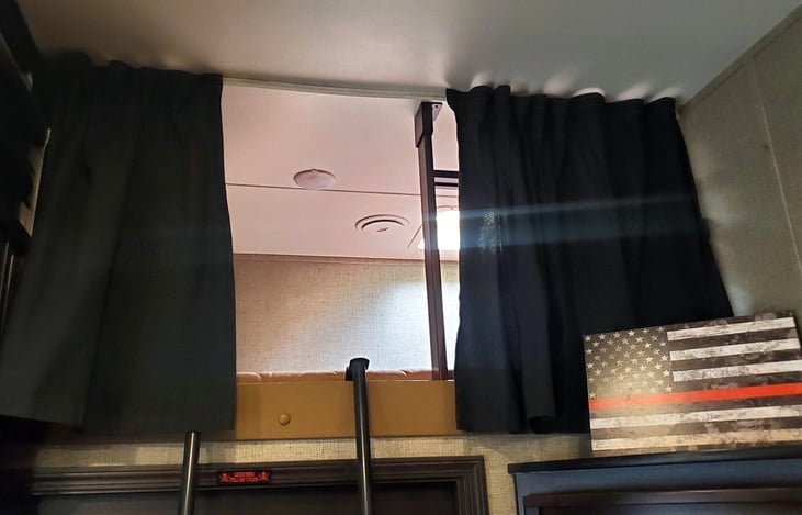 Upper twin bunk bed area with storage