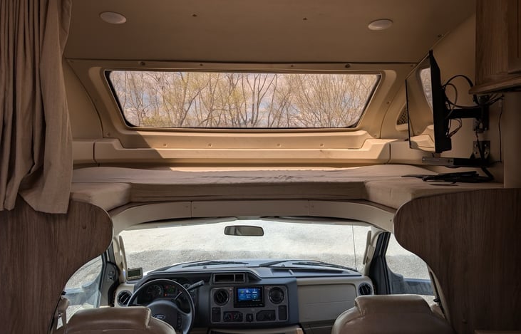 Spacious over-cab bunk with large viewing window and TV mount. Privacy curtains and comfortable mattress create the perfect kids' hideaway or extra sleeping space. Natural light floods through the pan