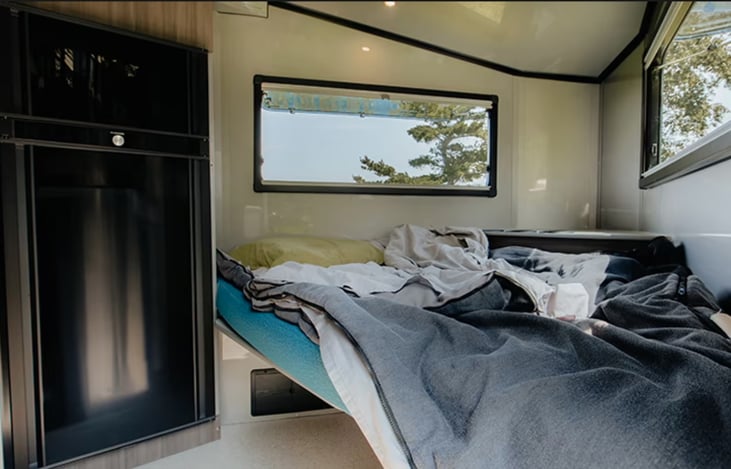 Front kitchen table converts to a non-standard queen-sized bed. Best for sleeping bags. I throw down a waterproof pet blanket for Charis when she's in the trailer.