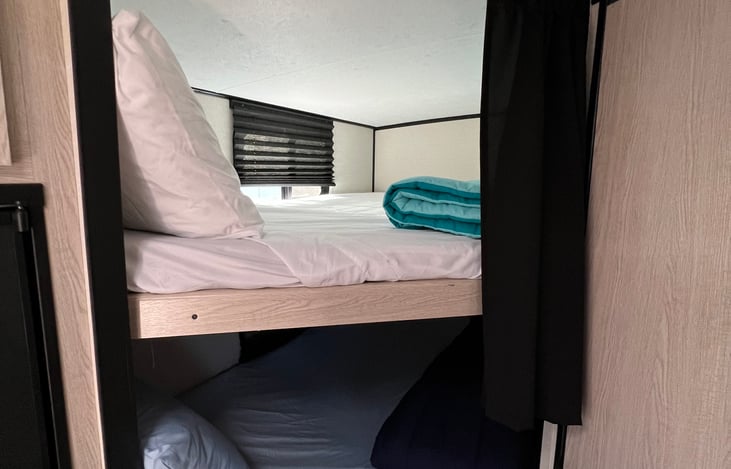 Top bunk with its own charging outlets and window to open for fresh air.