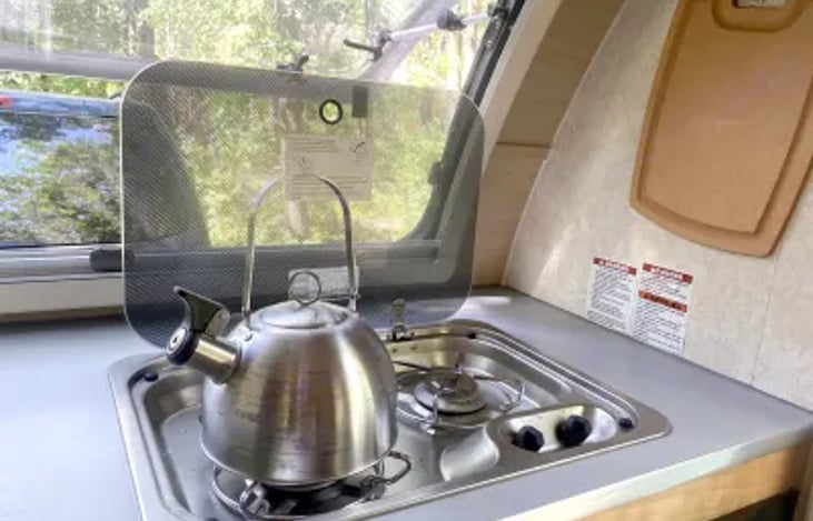 The dual burner gas stove is great for full meals or just heating coffee and tea. The glass cover acts as countertop space when not in use.