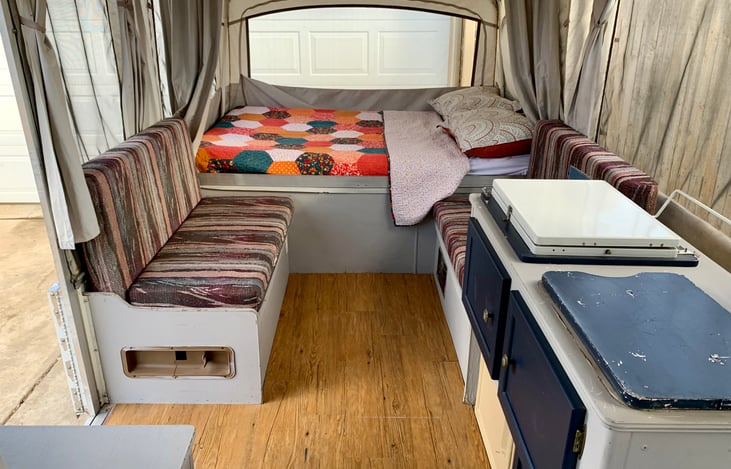 View looking towards the back bed, dual-couch (converts into a bed best suited for kids only) and mini-kitchen with stove and sink.