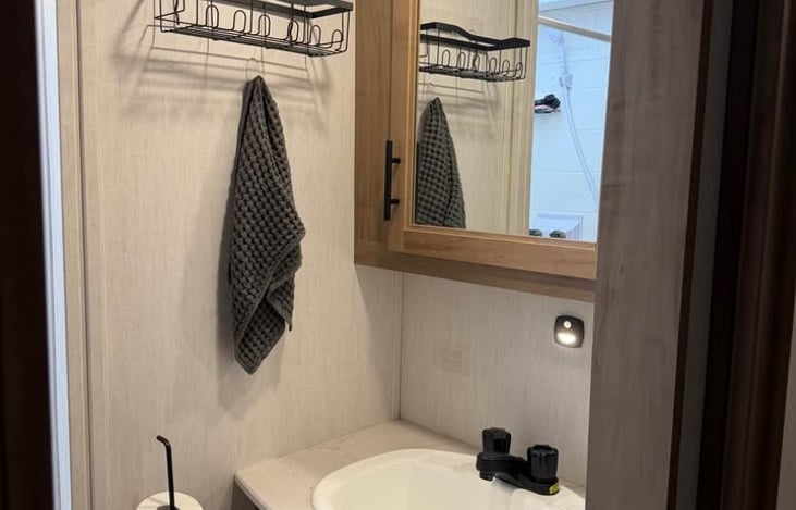 Spacious Bathroom with an oversized vanity and storage. Large enclosed shower equipped with retractable, splash-proof door and skylight to maximize headroom and natural light.