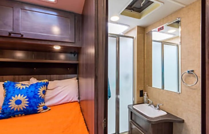 The bathroom has everything you need, including storage, a shower, toilet, and vanity!