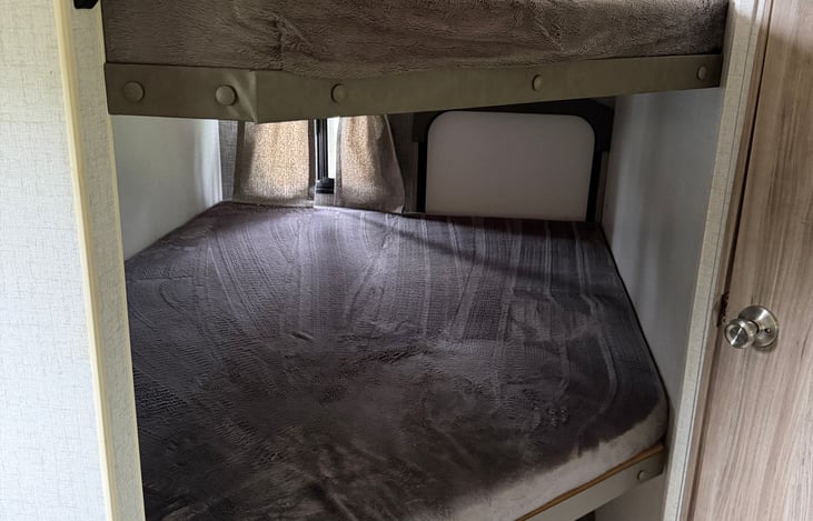 Bottom bunk, spacious (full sized bed) enough to easily sleep 2. Features USB/outlet as well as personal window to enjoy the view. Also folds up if need be, to allow full access to the 2nd door