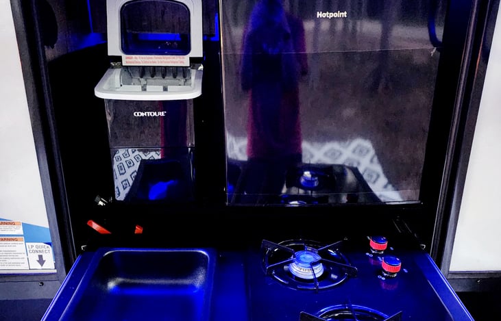 Outdoor kitchen includes a mini fridge, an ice maker and 2 burners.