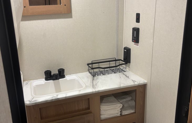 Bathroom stocked with bath towels, beach towels, and wash cloths. Door has hooks to hang towels to dry