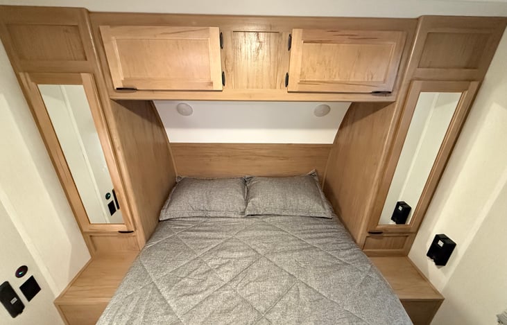 Master bed with storage on each side and above. TV mount at foot of bed.