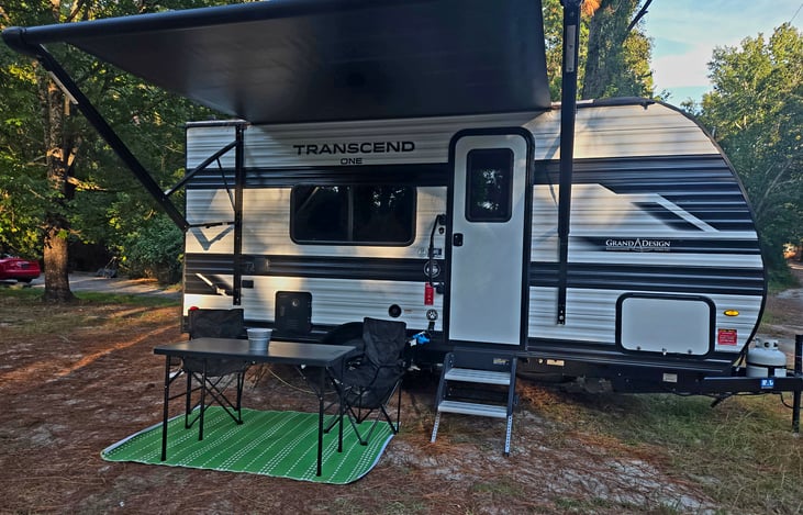 Has Awning, Bluetooth speakers, outdoor table, rug, 4 chairs, mini grill (it is charcoal or electric) have outdoor dart game, mini portable washing machine, has water filter, lg citronella candle.