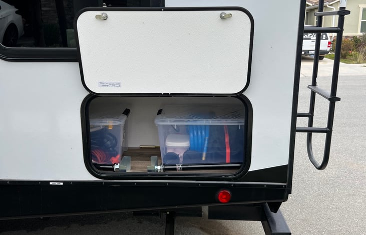 Storage containing separate clean water hose, filter and water pressure regulator. Surge protector and adaptor. Grey/Black water tank hose, sewer hose kit, and side winder.