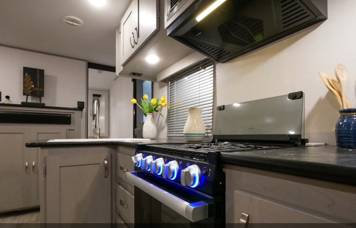 3 top Stove top, oven, hood vent, microwave, refrigerator, freezer, kitchen sink with good counter space considering an RV. Plenty of cabinet storage!