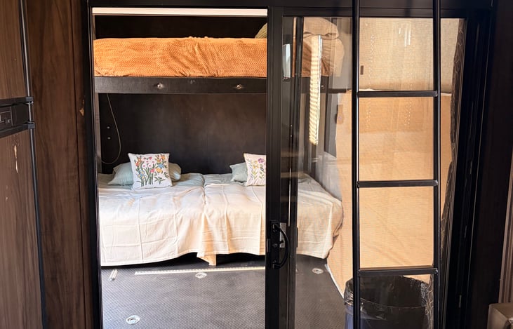 Garage space with two futons and one full size mattress. Ladder leads to a twin sized loft bed.