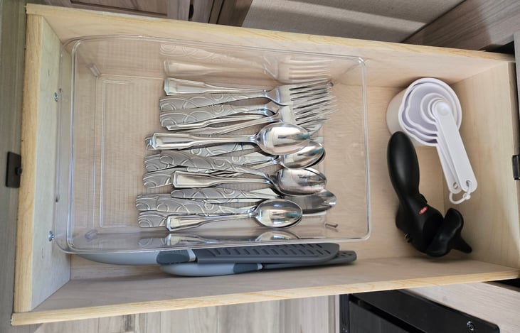 Silverware, measuring cups, can opener, (2) knives