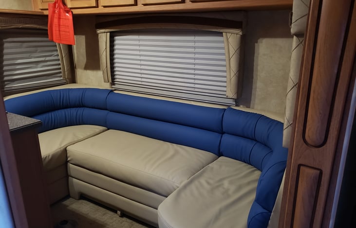 Living room /dining room seating area looking into kitchen and out-front door. will turn into a bed that sleeps two.