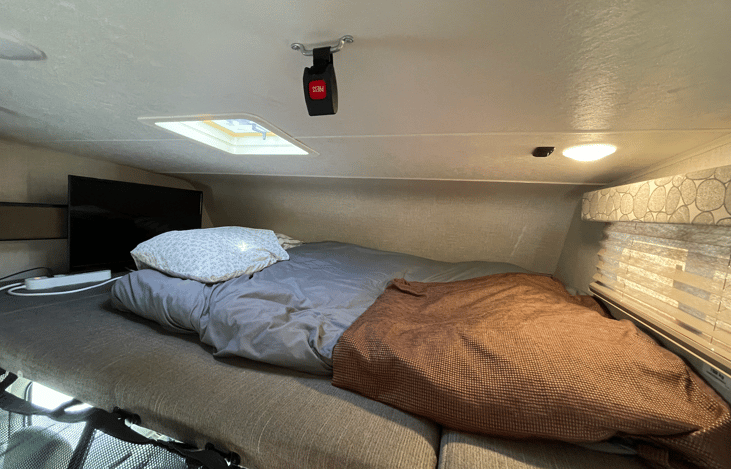 Spacious bunk bed, with protective seat belts to prevent falls.