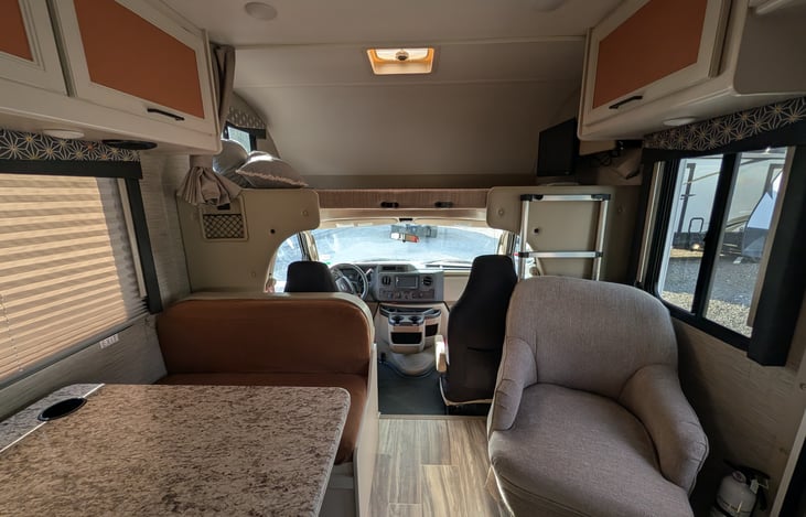 Bright, modern interior with a cute pop of color! Features a cozy rear queen bed, fully equipped kitchen, converting dinette, over-cab bunk, and an accent armchair. Clean, open, and ready for adventur