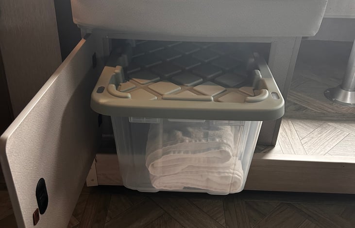 Storage bins under furniture hold extra linens and towels
