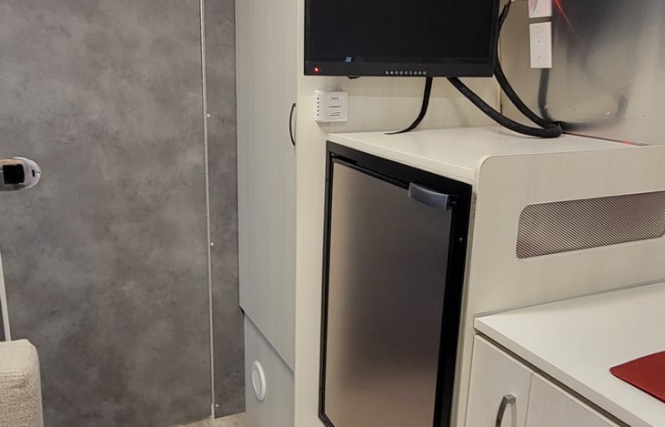 TV and Refrigerator/Freezer
The grey door opens into the bathroom.