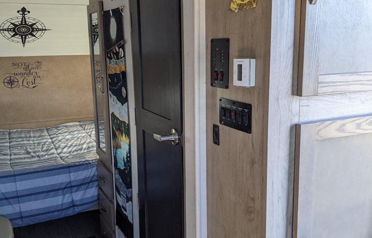 Indoor wet bath, control panel for electric awning, air/heat, and lights.