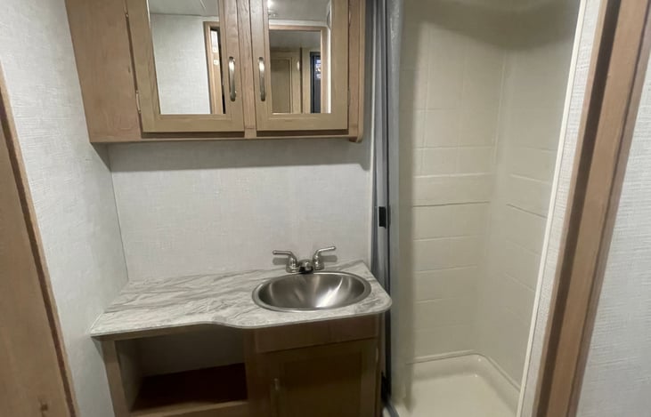 Stand up shower, facial sink, and toilet.