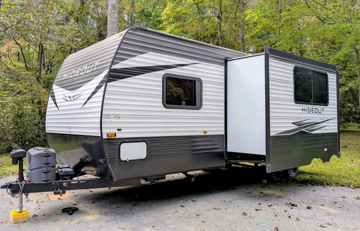 This spacious 2021 Keystone Hideout 250BH sleeps 8 with a bunkhouse  layout, outdoor kitchen, and upscale interior. Features include: electric fireplace, central vacuum, outdoor kitchen, and more.