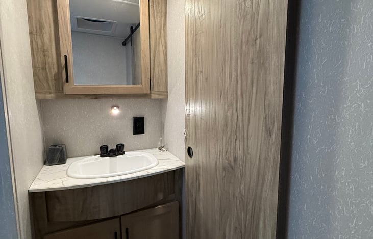 Bathroom with medicine cabinet, under sink storage and fan/ vent.
