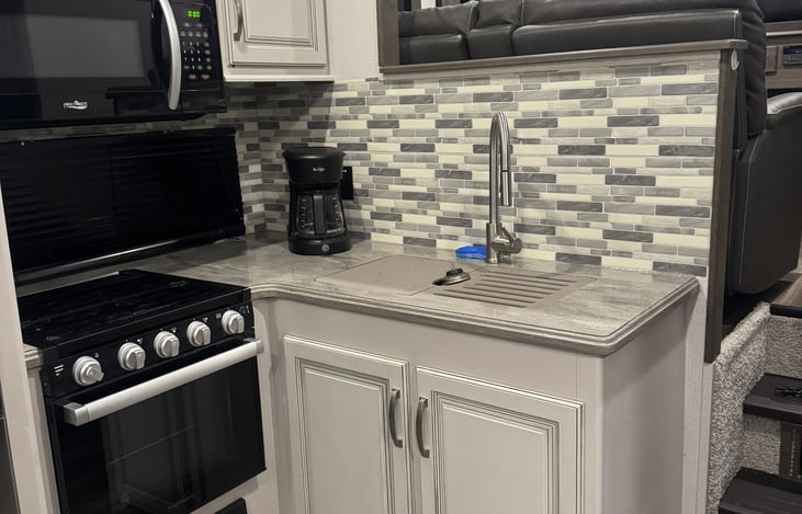 Kitchen sink, oven, and microwave.