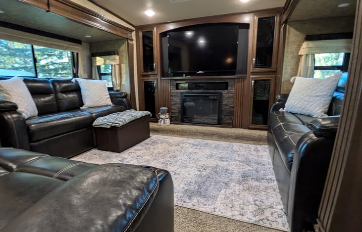 Living room with two sofas and a double recliner. TV, Radio, Bluetooth. Fireplace