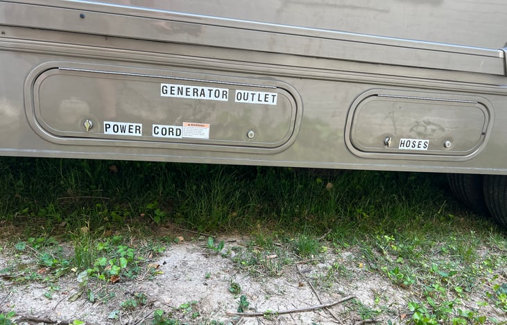 Power cord for campgrounds and outlet for the onboard Generator. (Left) water hoses (right)