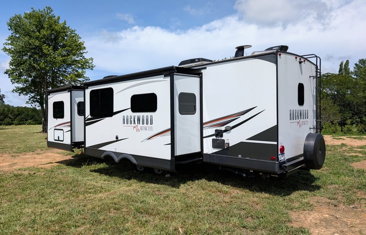 Luxury 35ft Rockwood Ultra Lite! Features dual slides, comfy recliners, private Queen suite with reading nook, full kitchen & outdoor grill setup. Windows throughout. Perfect glamping for up to 3!