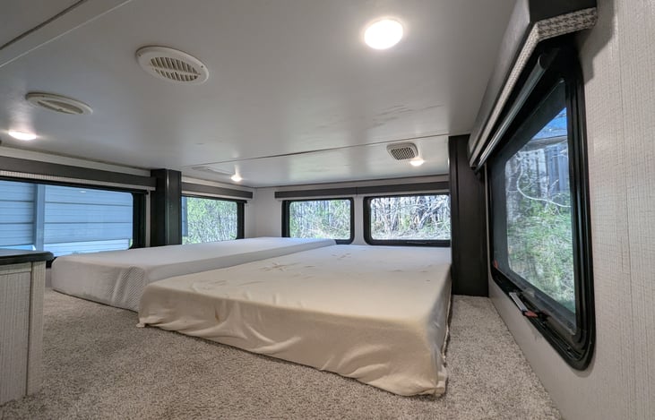 The perfect kid-zone! This cozy overhead loft provides a private sleeping nook or extra storage, complete with a comfortable mattress and safety railing, tucked away from the main living area.