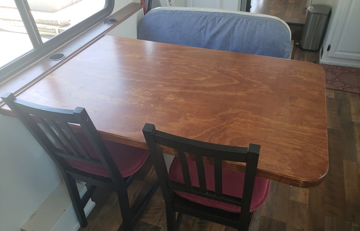 The dinette rear-facing bench has been removed and a custom oversized table and the two chairs make for plenty of eating space.