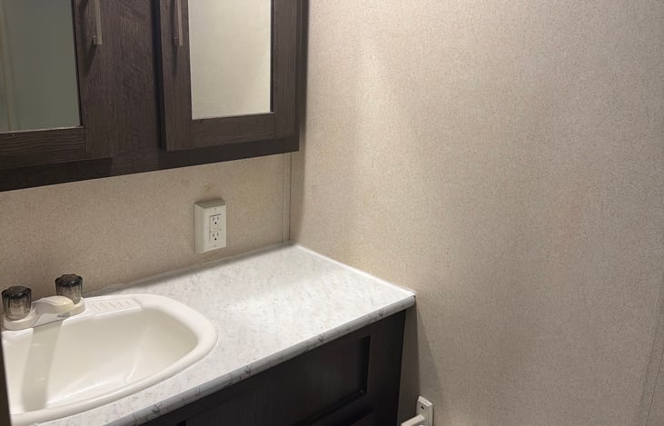 Bathroom sink w/counter and medicine cabinet with plenty of storage.