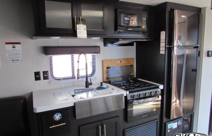 Kitchen with oven and stove, microwave, full sink, cabinets and full Refrigerator/Freezer