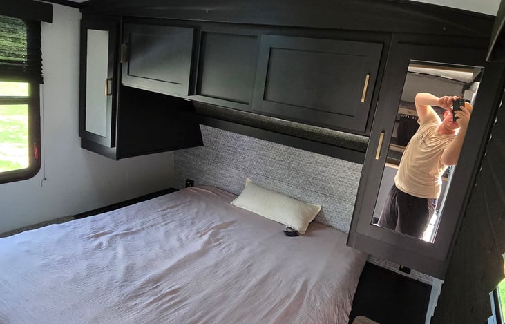 Master bedroom has a queen size bed and good amount of storage and a laundry door that goes in to the front storage compartment