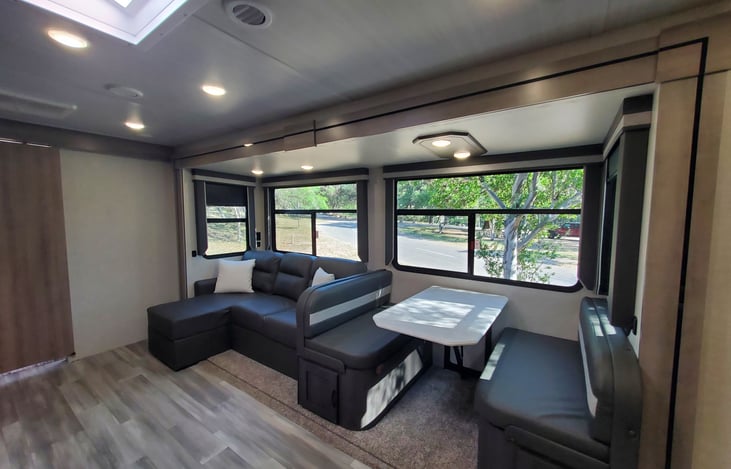 Full bank of windows on all sides of slide-out. Chaise tri-fold sofa fold out to sleep one and booth flattens to sleep one. USB charging ports throughout.