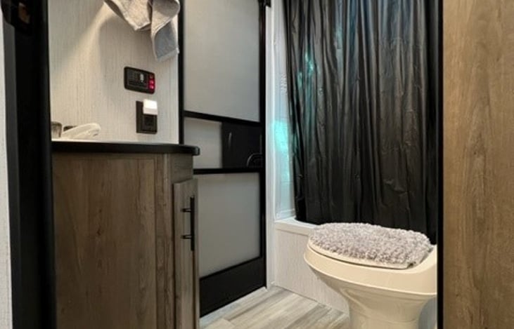 Shower with towels enough to accommodate 5 adults; 2nd exit to outside and overhead sink storage.