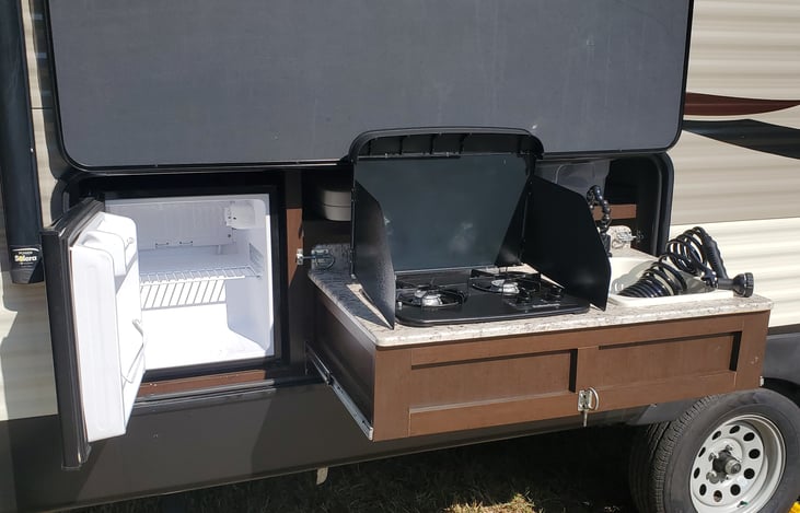 Outdoor kitchen - electric refrigerator, two burner gas stove and sink with shower attachment