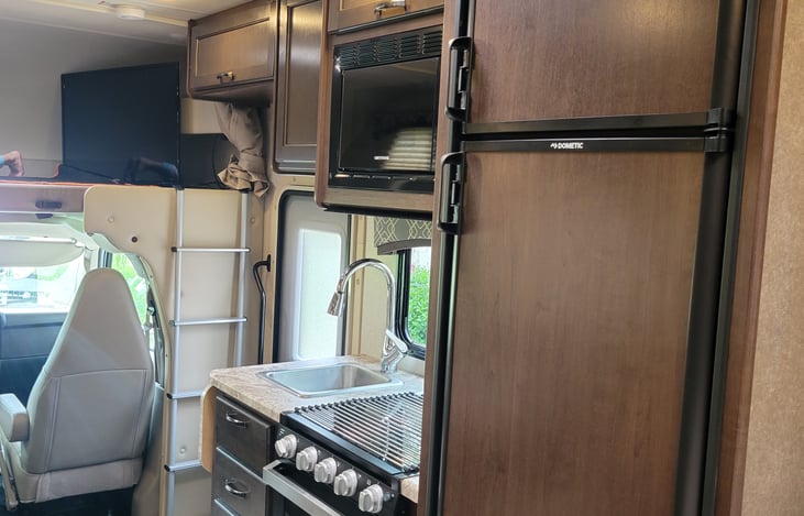 Microwave, oven, and 3 burner stove all with the pots, pans and utensils you need for your journey.