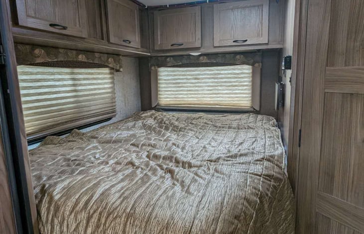 Comfortable queen size bed with overhead cabinets, charging station and folding table for your phone/glasses.