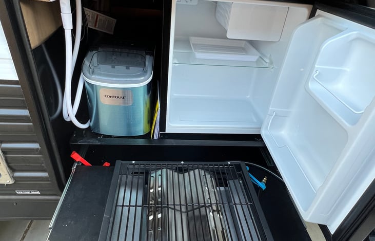 Grill and refrigerator outside with a ice maker