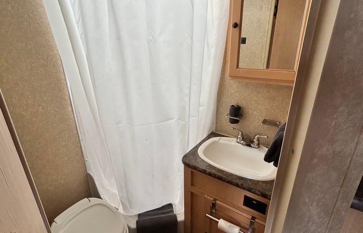 Full bathroom with toilet, sink, medicine cabinet, and 24" x 32" stall shower.