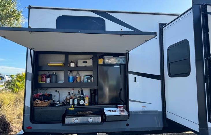 The outdoor kitchen - wet sink, mini fridge and Blackstone griddle. A propane BBQ grill easily installs to the right of the kitchen.