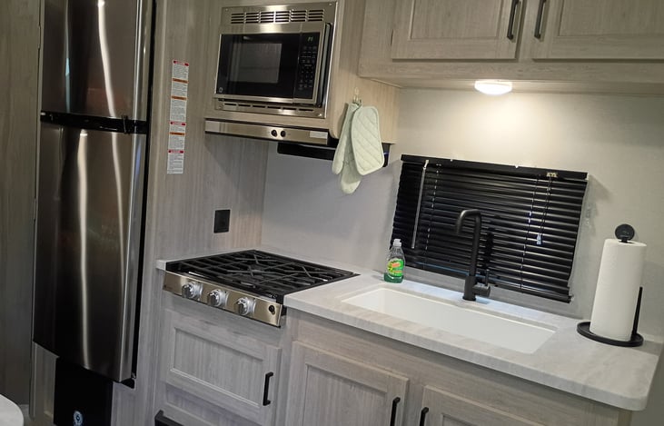 Kitchen has a fridge, microwave and stove top. No oven.