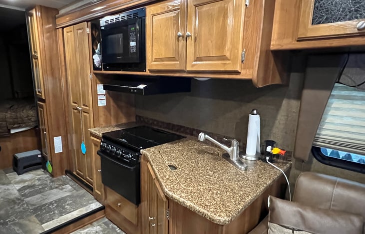 Kitchen area: stove top, microwave, oven, sink. Stocked with lots of basic supplies. Complete supply listed will be provided. Large pantry cabinet with slide out drawers.