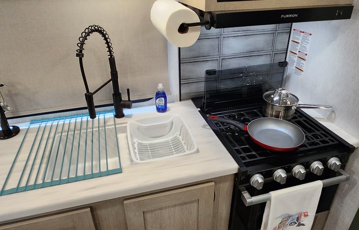 Residential size kitchen sink & faucet. Gas stove & oven available, with cookware included.