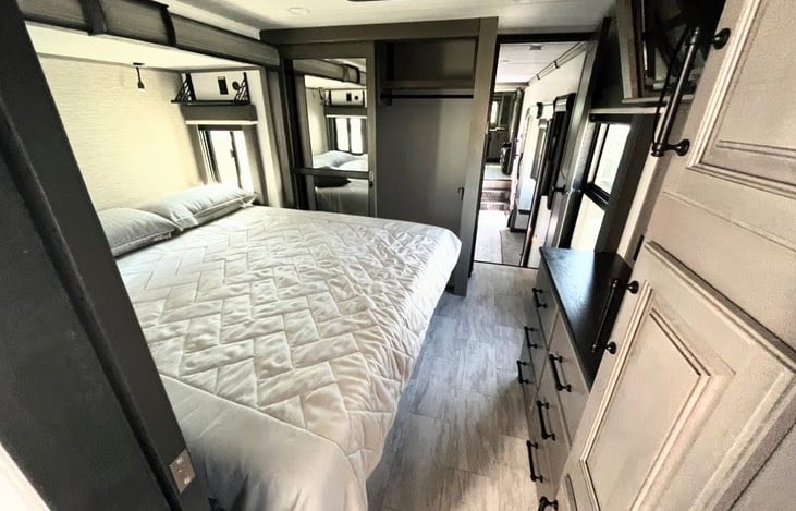 Retreat to a true rear-axle master suite designed for total rest and privacy. This bedroom features a large TV and walk-around King bed nestled in its own slide-out, providing a spacious, residential