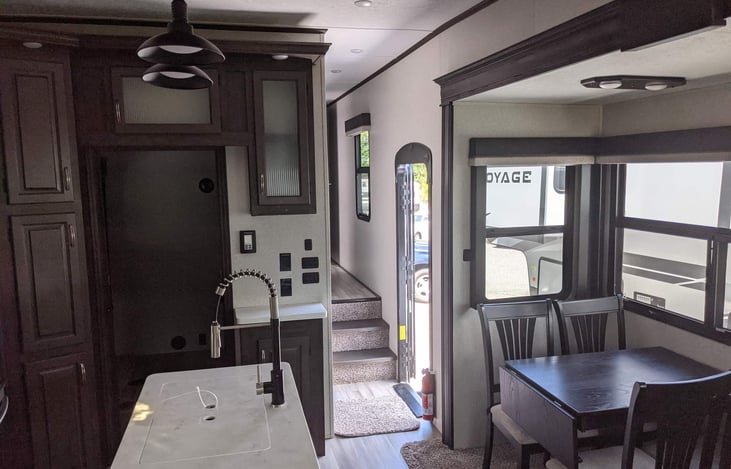 Dinning table and view of kitchen island and front door and bunk room.