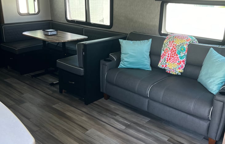 Living area with U shaped dinette. Sofa and dinette both convert to a bed.